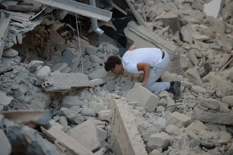 Young man trying to find any  survivors after earthquake